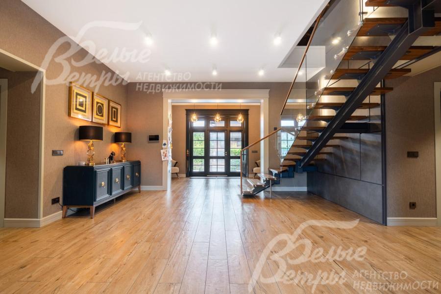 В просторном холле установлен консольный столик тёмно-синего цвета с металлическими ножками