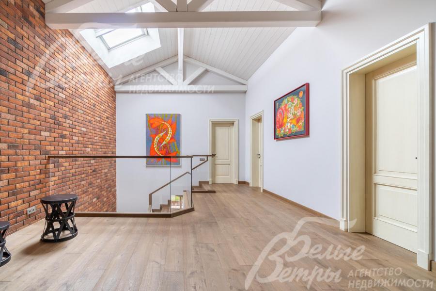 Холл второго этажа с акцентной стеной, оформленной в стиле лофт, массивными балками  и мансардными окнами Velux. Двери - из массива каштана с сатиновым покрытием