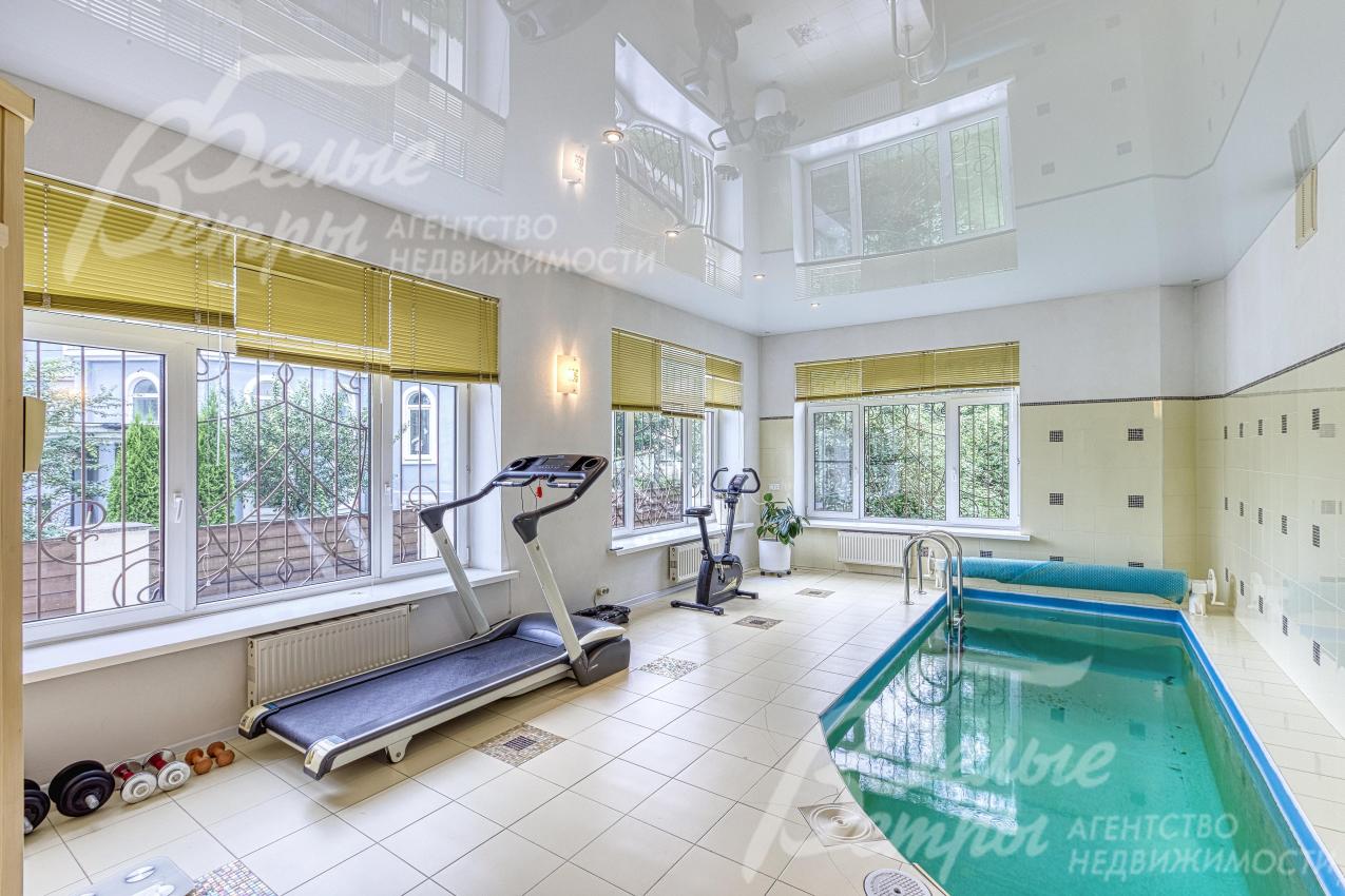 На первом этаже располагается зона бассейна с большими окнами и тренажёрами