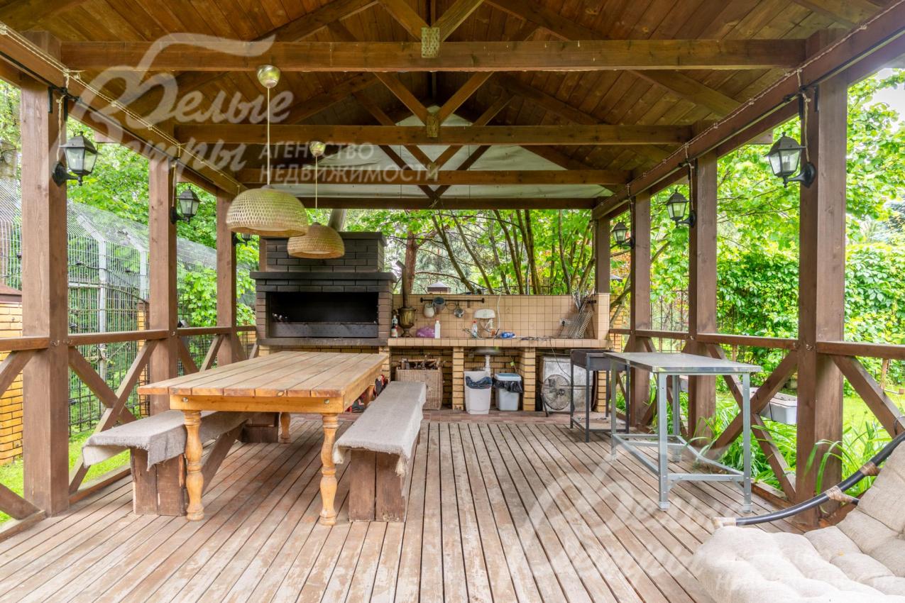 В беседке установлен мангал, деревянная мебель
