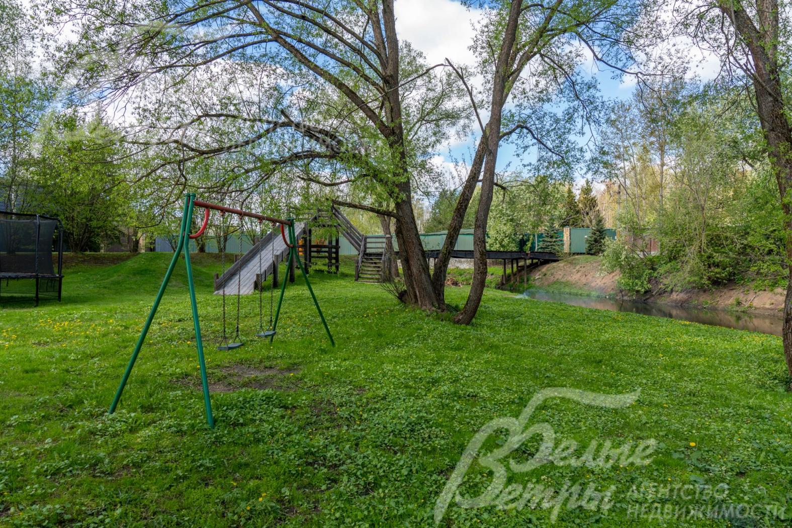 Детская площадка у реки в центре коттеджного посёлка
