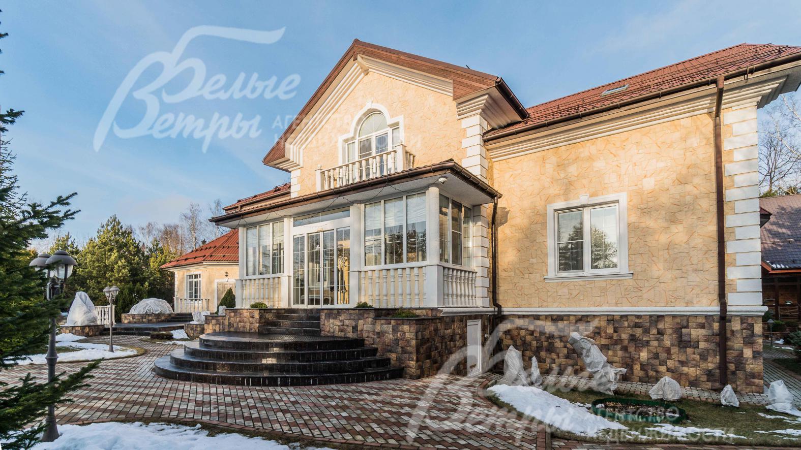 Фасад дома из натурального камня, крыльцо выполнено из гранита