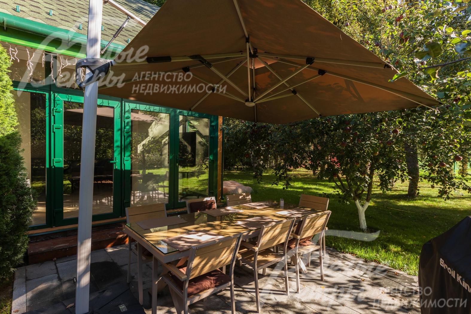 На террасе гостевого дома (выход из кухни-гостиной) установлен тент и садовая мебель