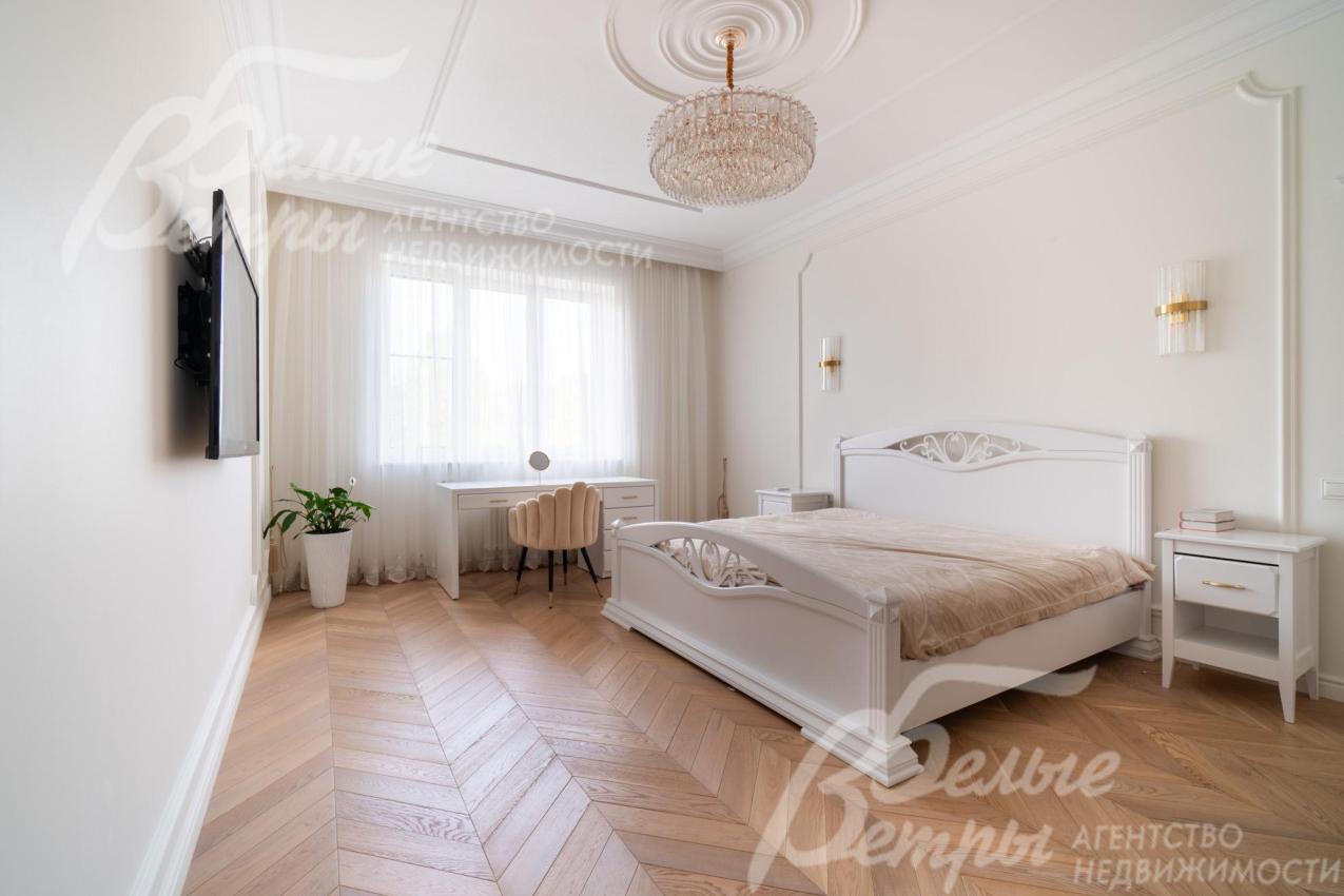 Одна из комнат на втором этаже с кроватью, телевизором и рабочим местом