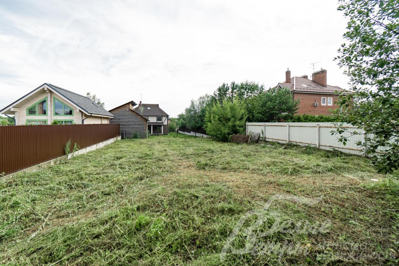 Ровный участок по периметру огорожен забором