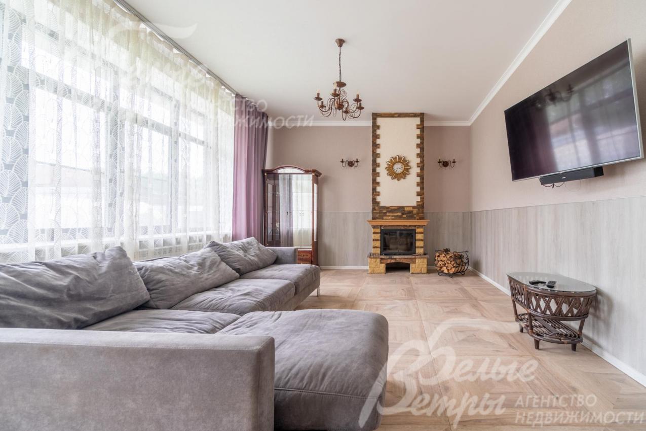 Гостиную украшает камин, есть большой диван и плазменный телевизор