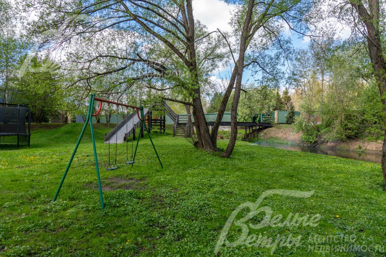 Детская площадка у реки в центре коттеджного посёлка