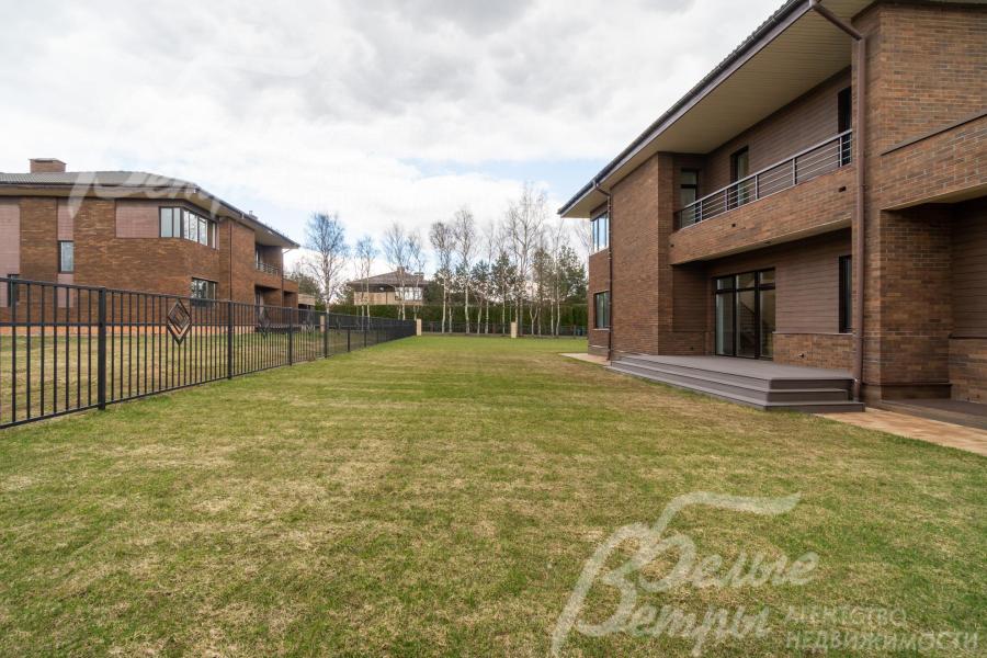 Участок огорожен кованым забором в едином стиле поселка