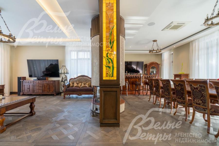 В зонировании гостиной и столовой - массивная колонна с витражом