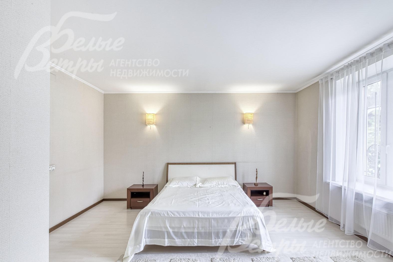 Одна из спален на втором этаже с кроватью и прикроватными тумбами