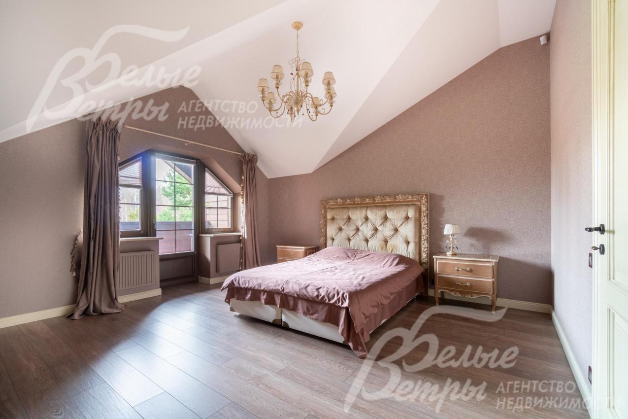 Элегантная спальня на втором этаже с мансардной крышей и с выходом на террасу