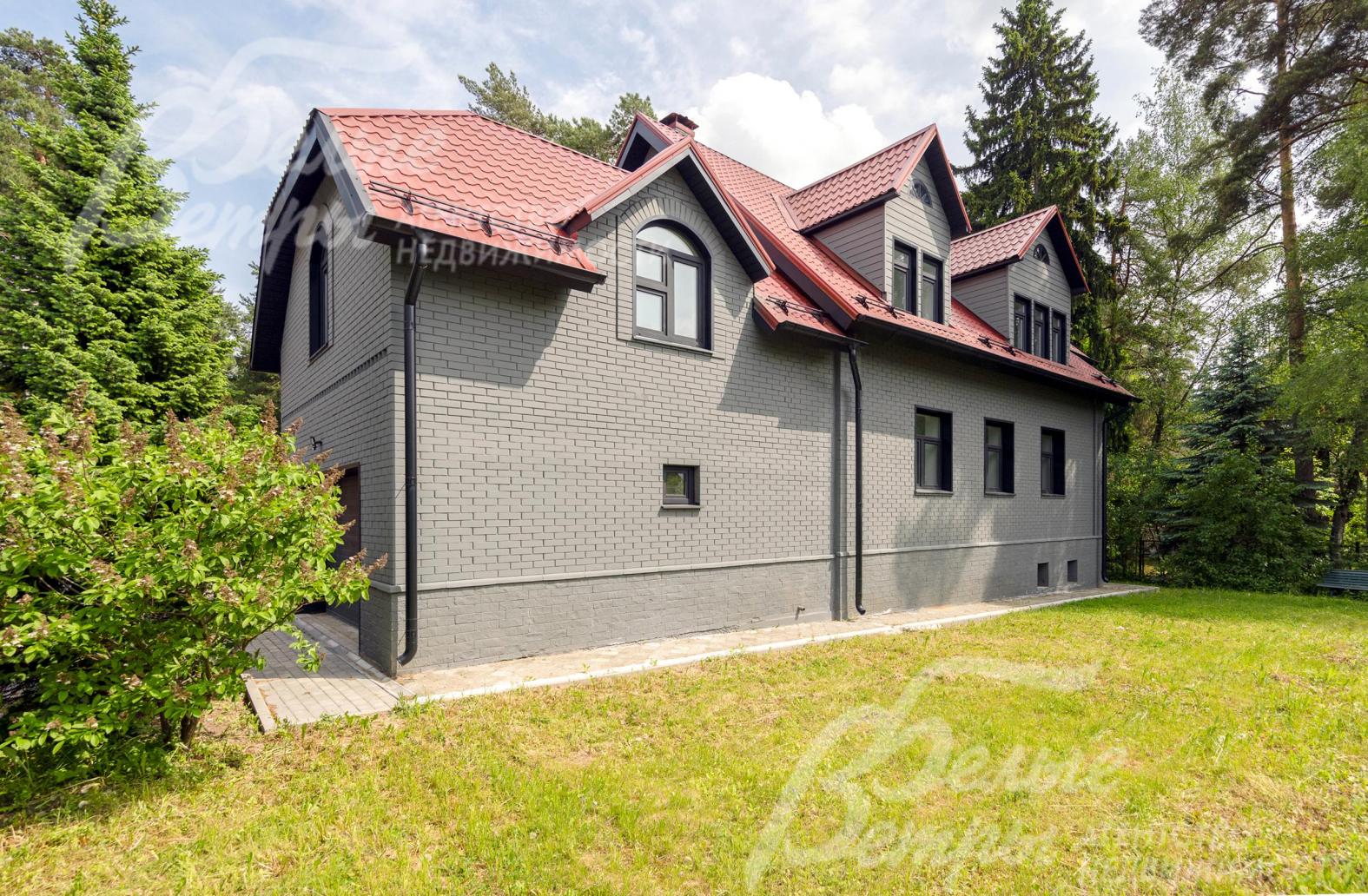 Дом стоит на зелёном благоустроенном участке, оформленном по проекту ландшафтного дизайна