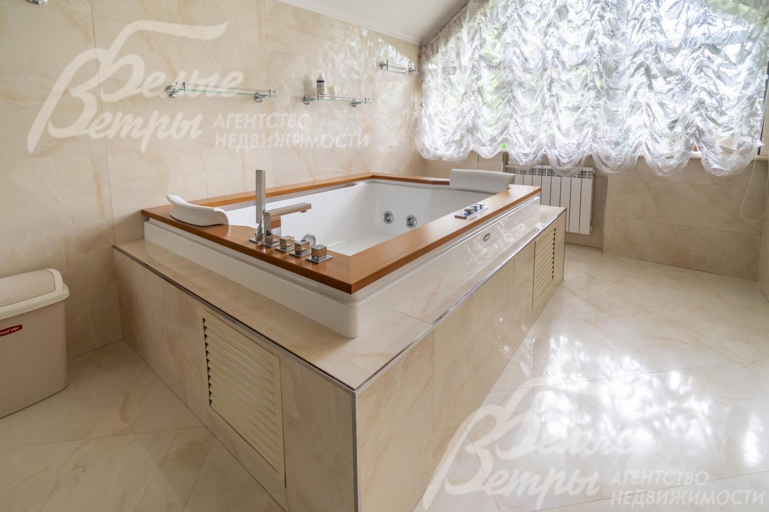 Комфортная большая ванна с подголовниками и отделкой бортиков под дерево