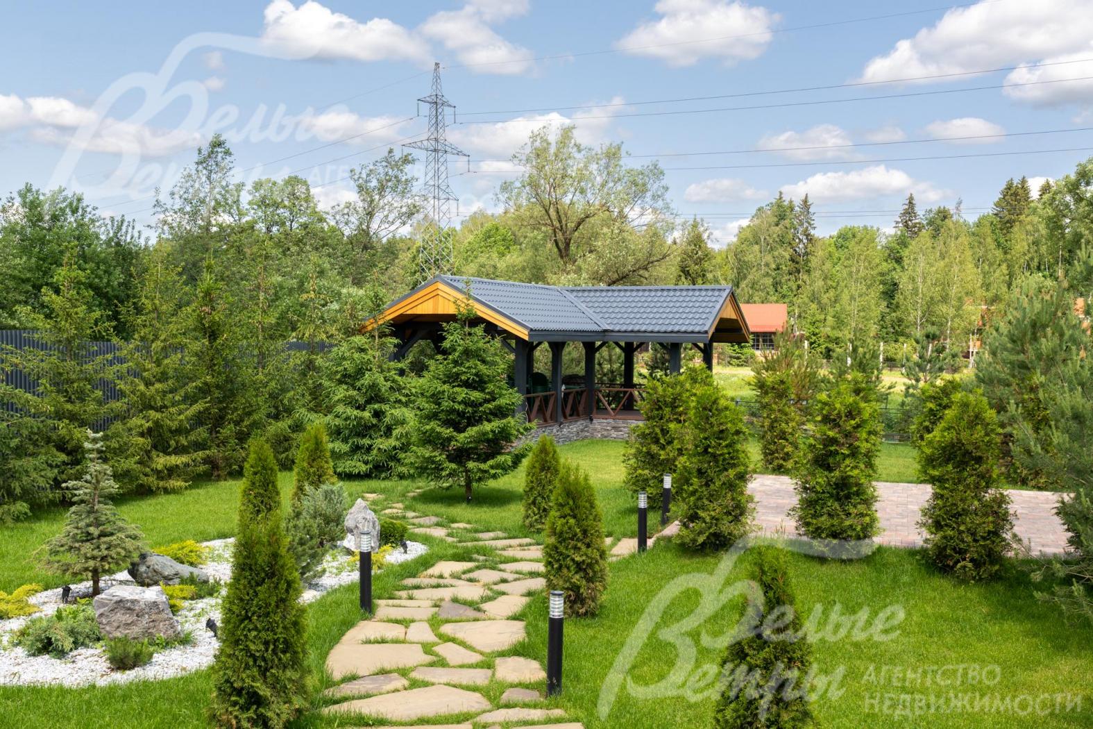 Дом стоит на зелёном ухоженном участке с парковым ландшафтным дизайном
