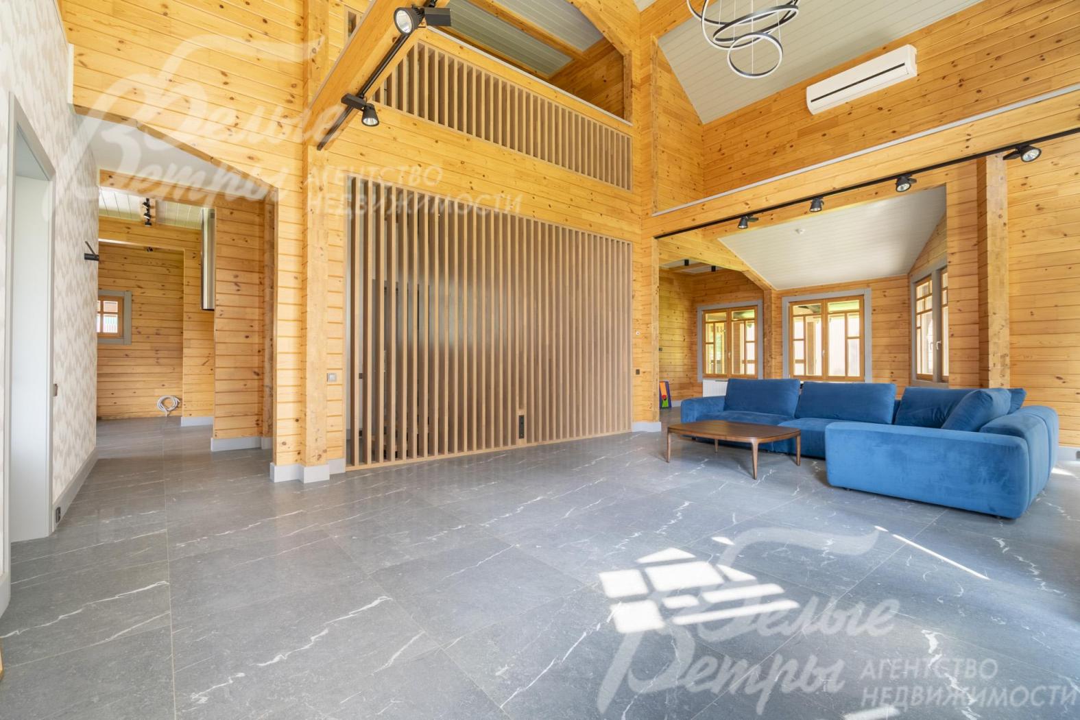 Пространство гостиной от лестницы изящно отделяет декоративная стена из массивных натуральных дубовых реек 