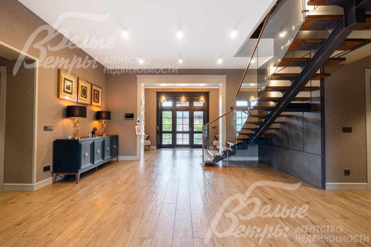 В просторном холле установлен консольный столик тёмно-синего цвета с металлическими ножками