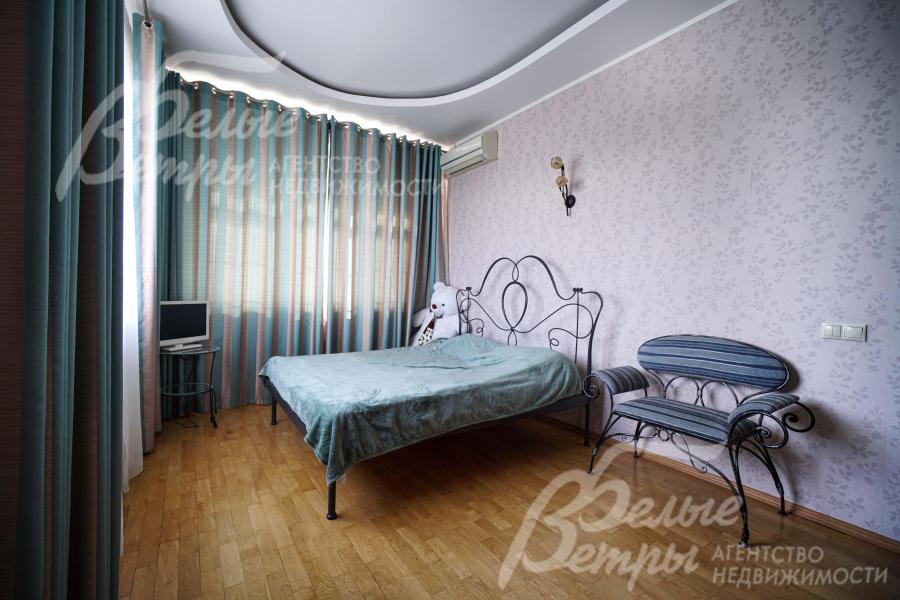 Одна из спален на втором этаже в бирюзово-серых оттенках с кованой мебелью