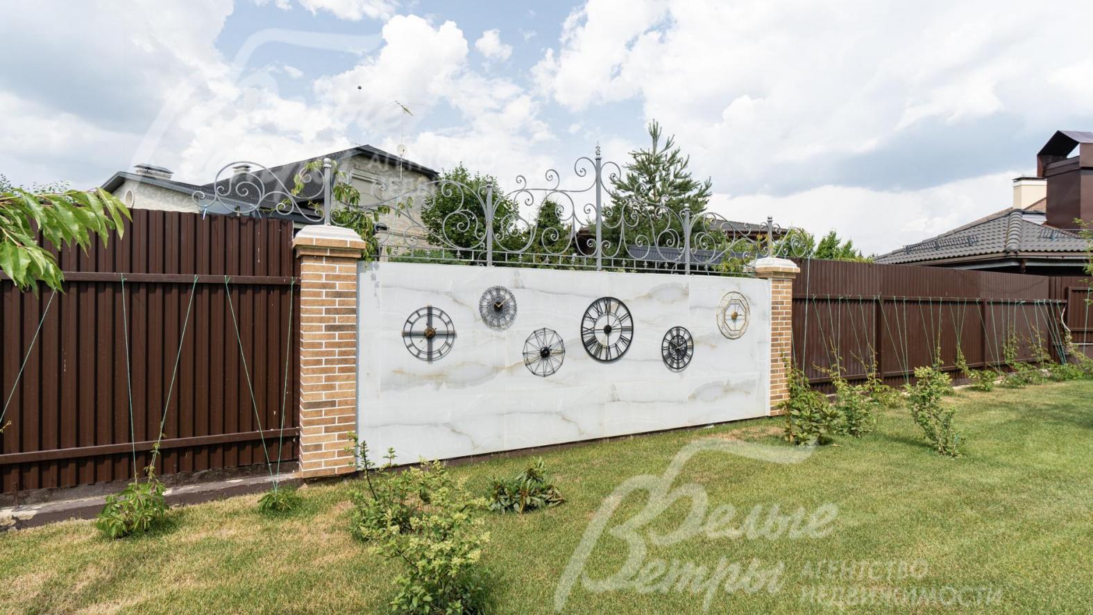 Участок огорожен забором из металл. профиля на бетонном фундаменте с кирпичными столбами, высотой 2 м