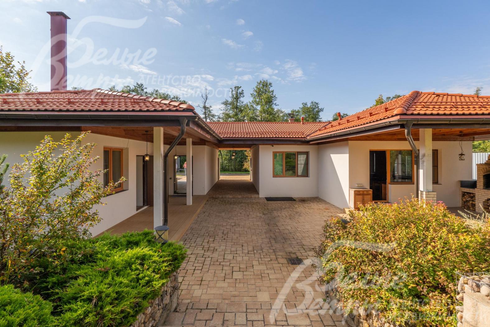 Сервисный дом построен в едином стиле с основным домом: большие свесы, стены отделаны штукатуркой белого цвета