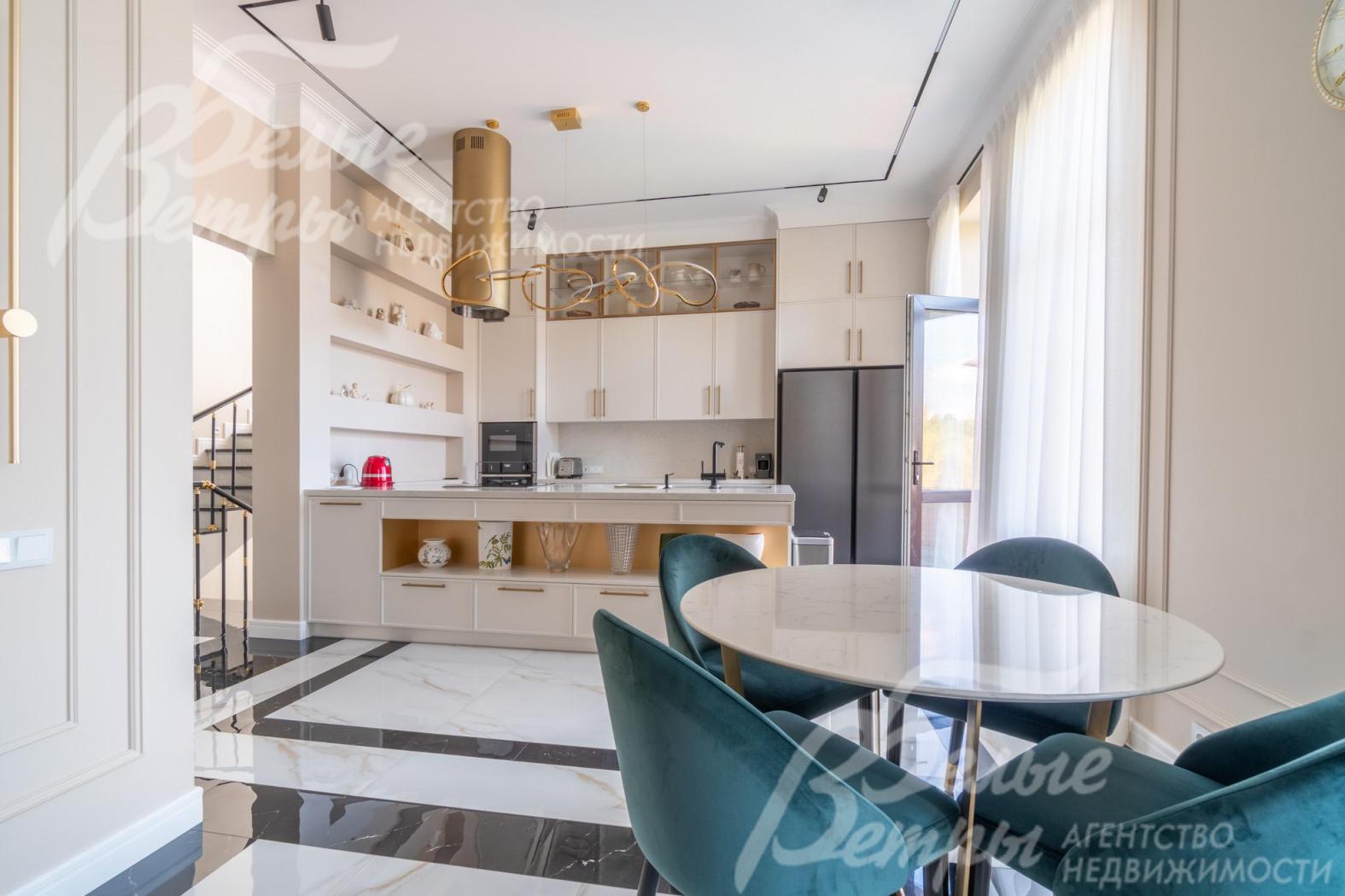 Зона кухни-столовой совмещена с гостиной, зонирована системой стильных шкафов