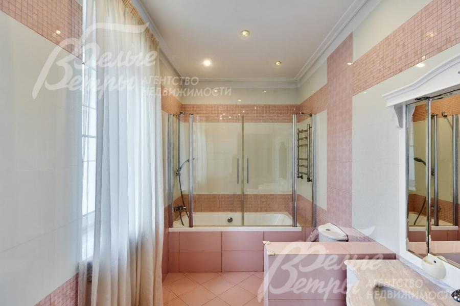 Один из санузлов на втором этаже в светло-розовых тонах с ванной со стеклянной ширмой