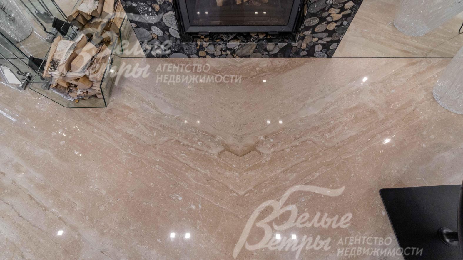 В гостиной и холле пол отделан итальянским мрамором из слэба сорта Daino-Venato с укладкой "бабочка"