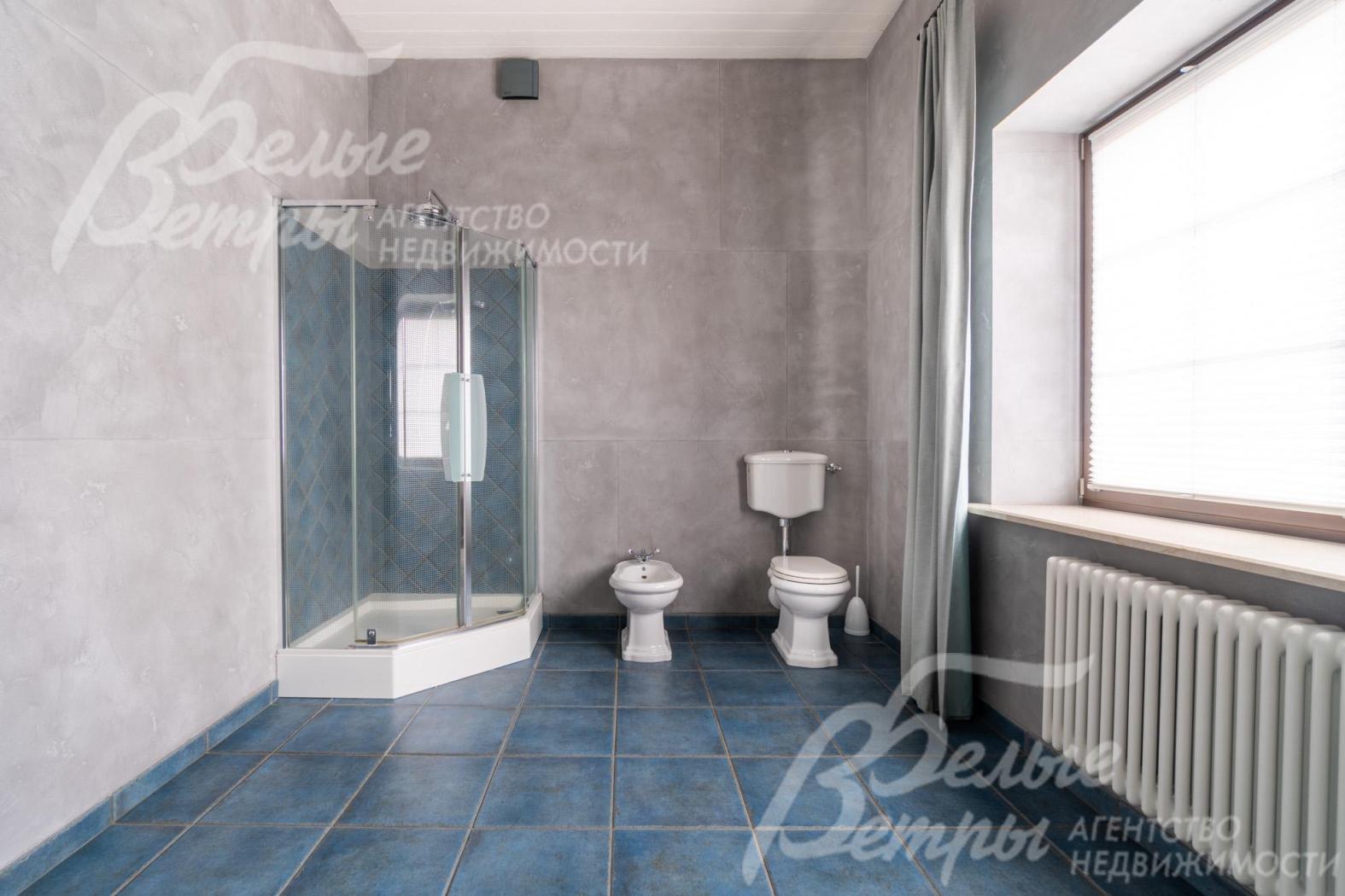 В санузле - угловая душевая кабина, унитаз и биде, большое окно