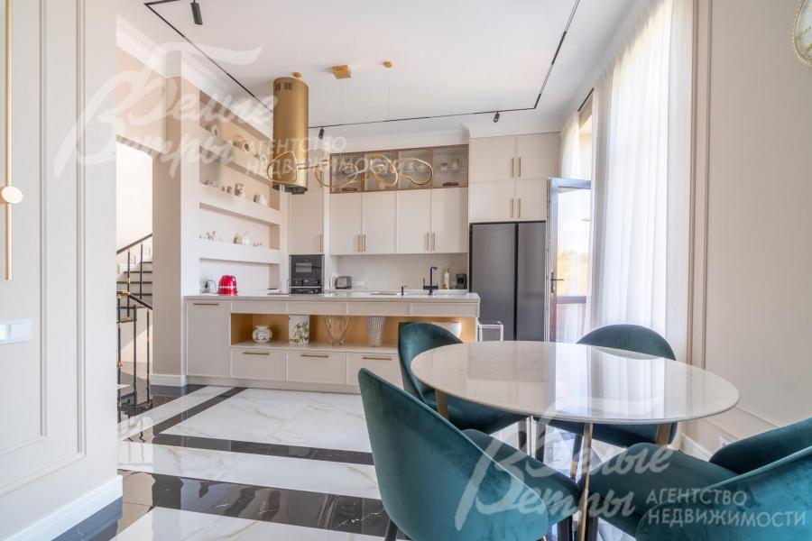 Зона кухни-столовой совмещена с гостиной, зонирована системой стильных шкафов