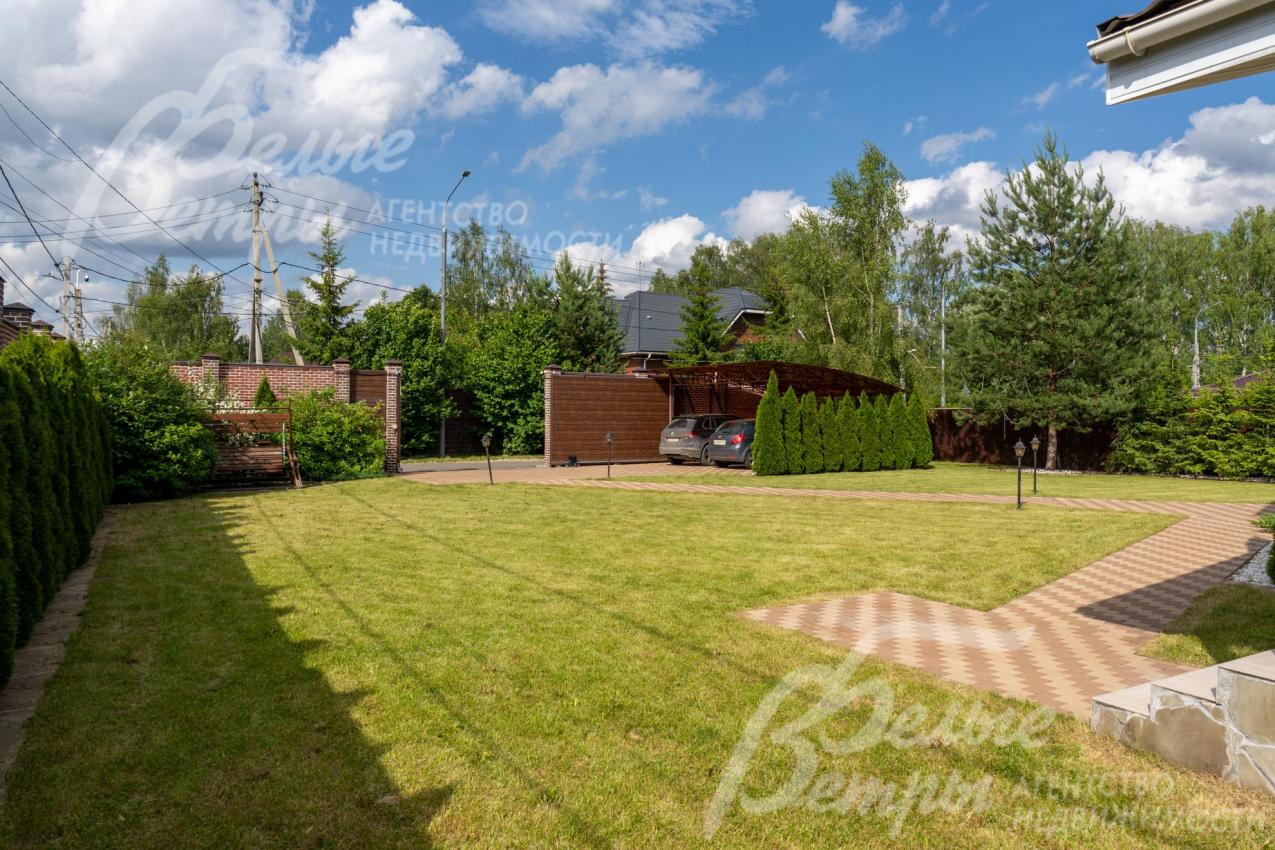 У въезда на участок - парковка под навесом для 2-х автомобилей, с правой стороны - живая изгородь из туй