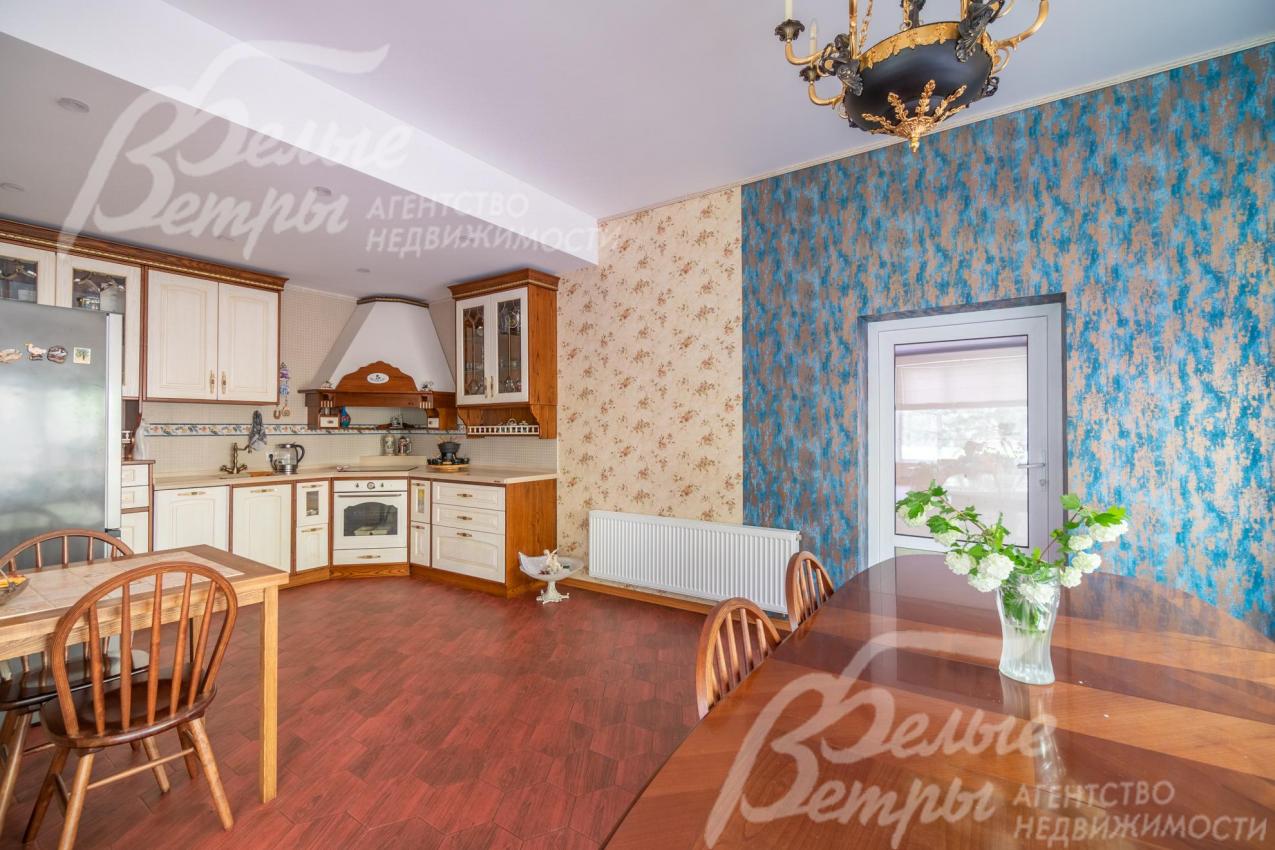 Открытое пространство кухни и столовой, зонированное обоями