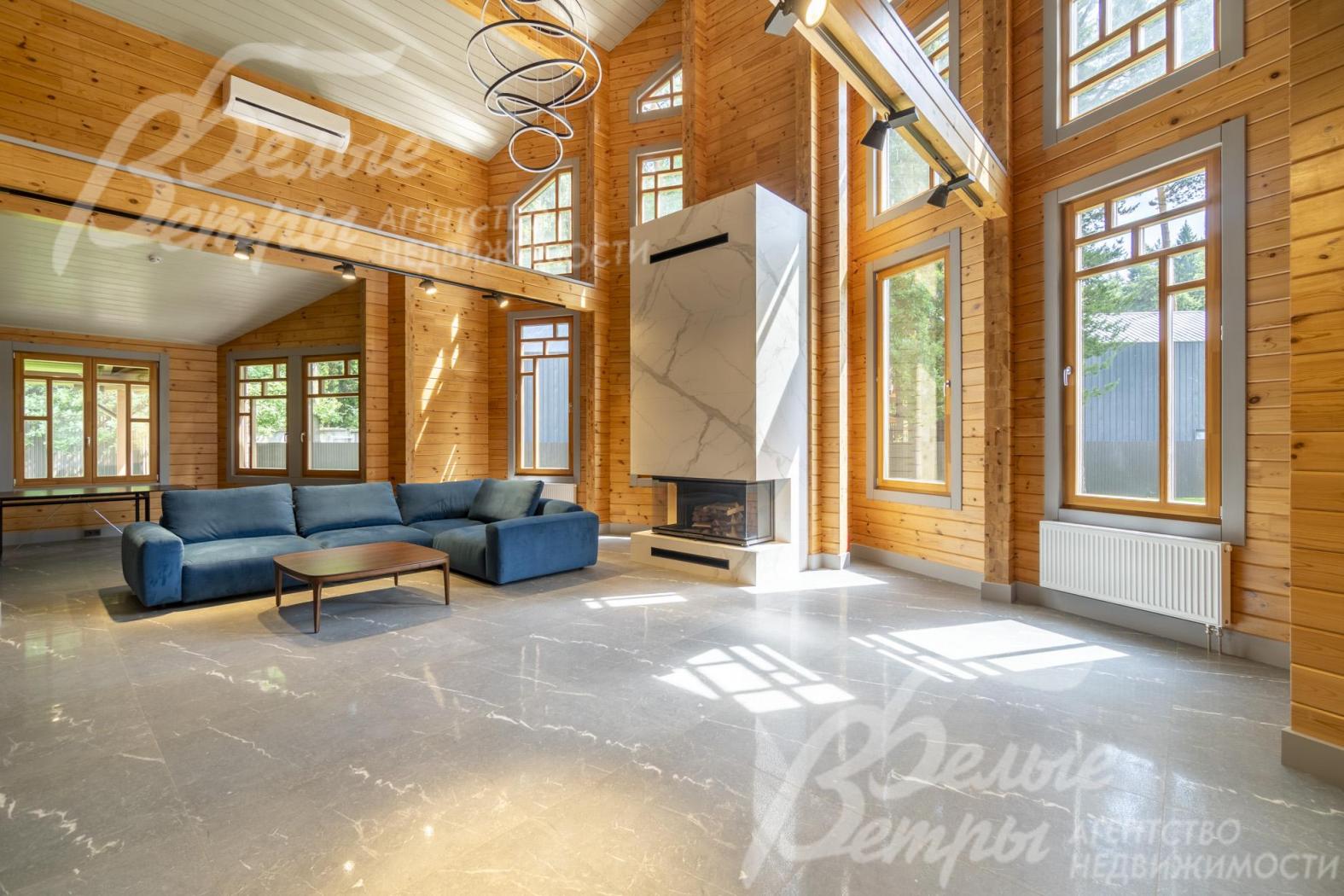 Просторная и светлая двухсветная гостиная, с трехсторонним камином