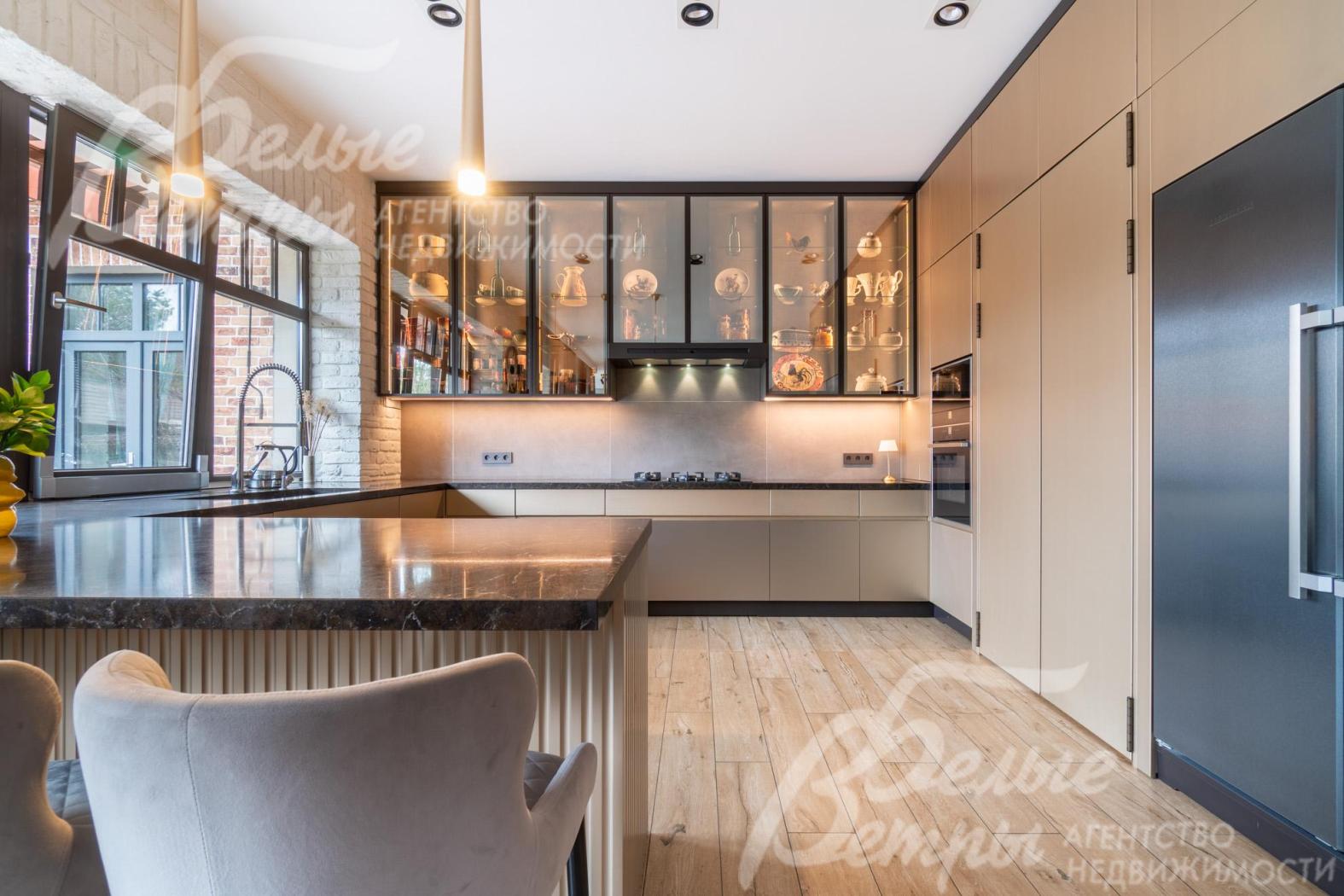 На кухне установлен премиальный гарнитур «Джулия Новарс» с высокими шкафами-витринами с эффектной подсветкой