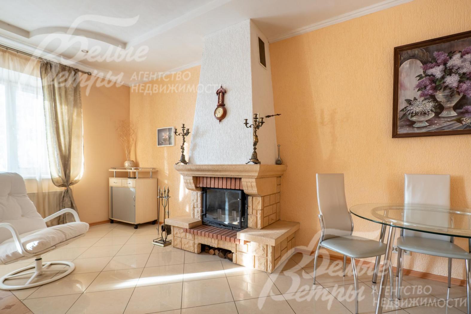 Гостиную украшает дровяной камин гильотинного типа с отделкой в общем стиле интерьера