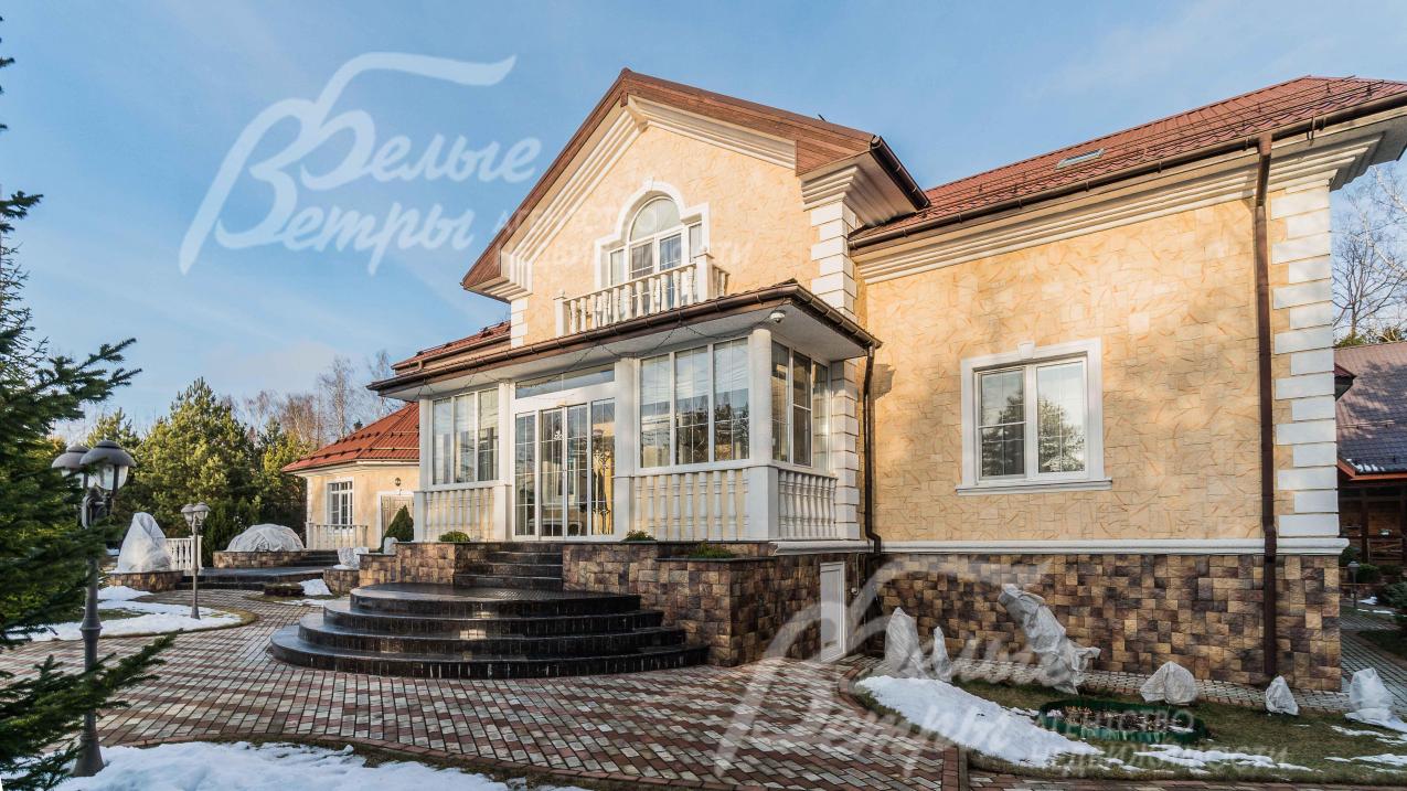 Фасад дома из натурального камня, крыльцо выполнено из гранита