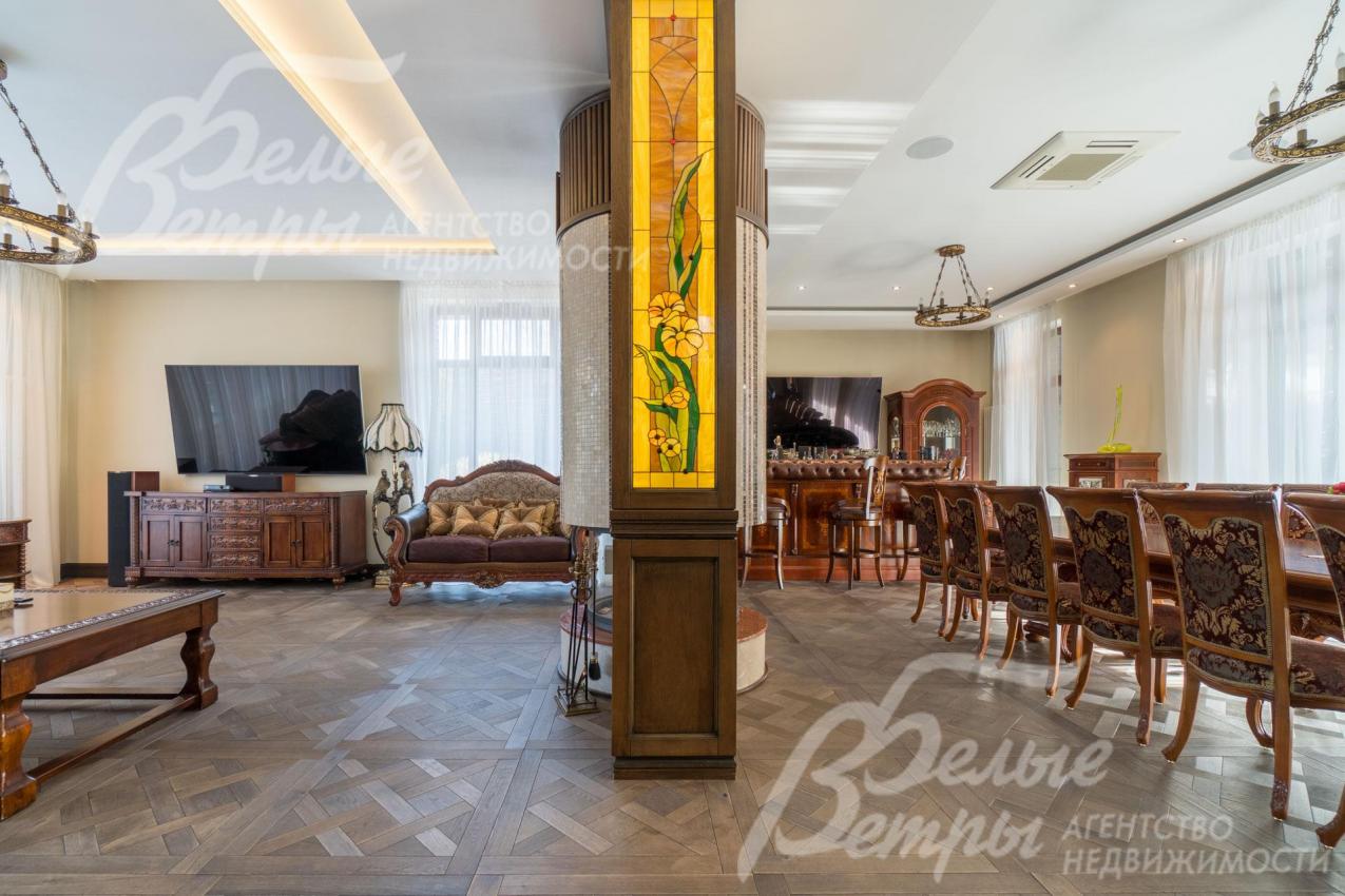 В зонировании гостиной и столовой - массивная колонна с витражом