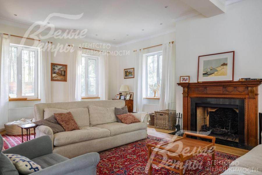 Уютная гостиная с большим камином и антикварным английским деревянным порталом.