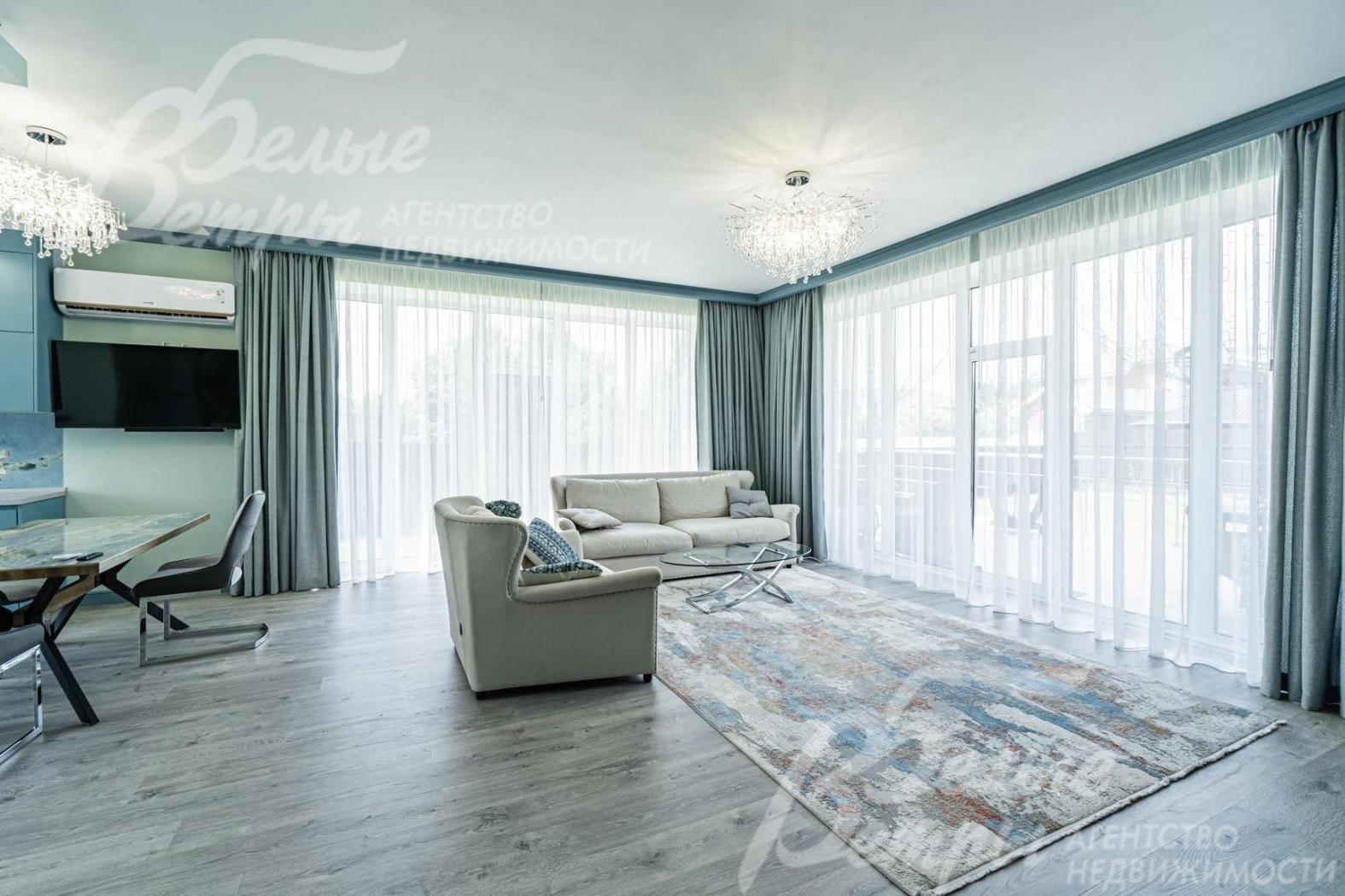 Зона гостиной с панорамными окнами и выходом на террасу