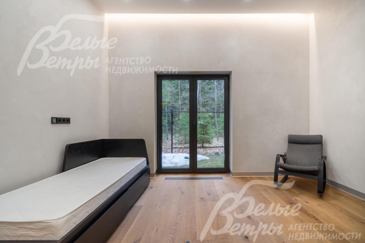 Одна из спален находится на первом этаже с большим окном в пол и эффектным скрытым освещением