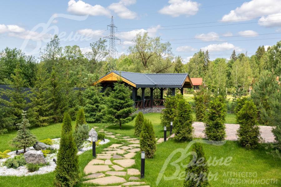 Дом стоит на зелёном ухоженном участке с парковым ландшафтным дизайном