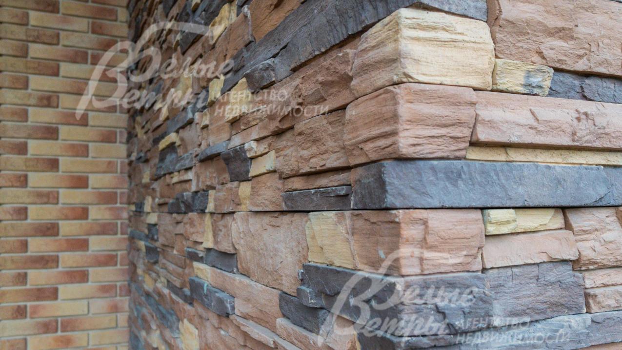 Фасад -дикий камень, декоративная штукатурка «короед». Цоколь облицован искусственным камнем.