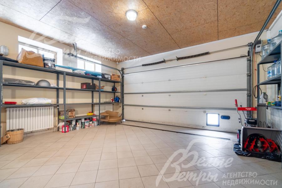 На первом этаже находится гараж, рассчитанный на два автомобиля и дополненный стеллажами