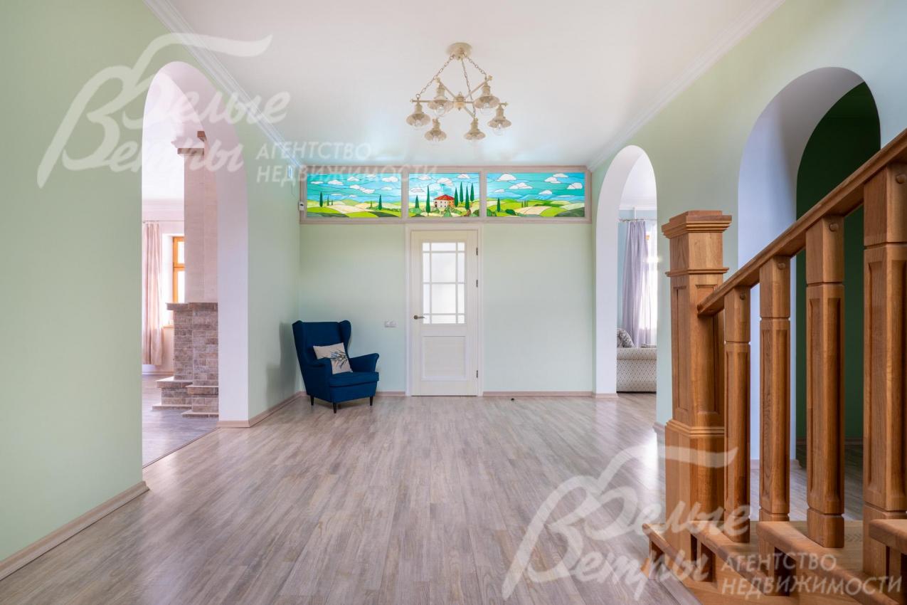 Холл первого этажа с витражом. На второй этаж ведёт монолитная лестница, отделанная массивом дуба