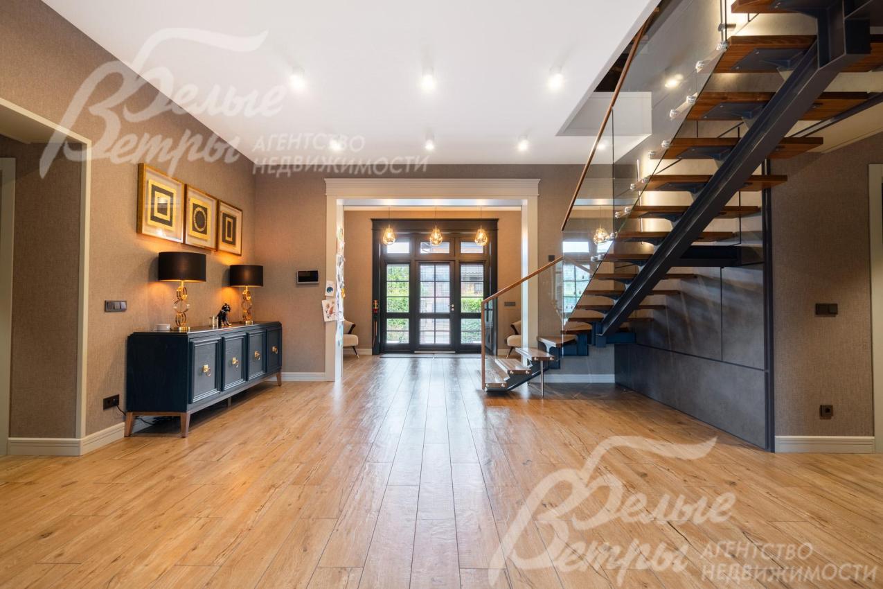 В просторном холле установлен консольный столик тёмно-синего цвета с металлическими ножками