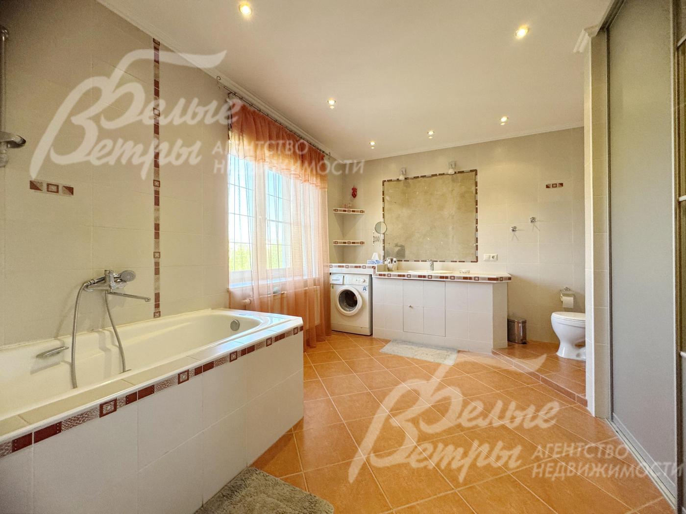 Просторный санузел с ванной и стиральной машиной на втором этаже