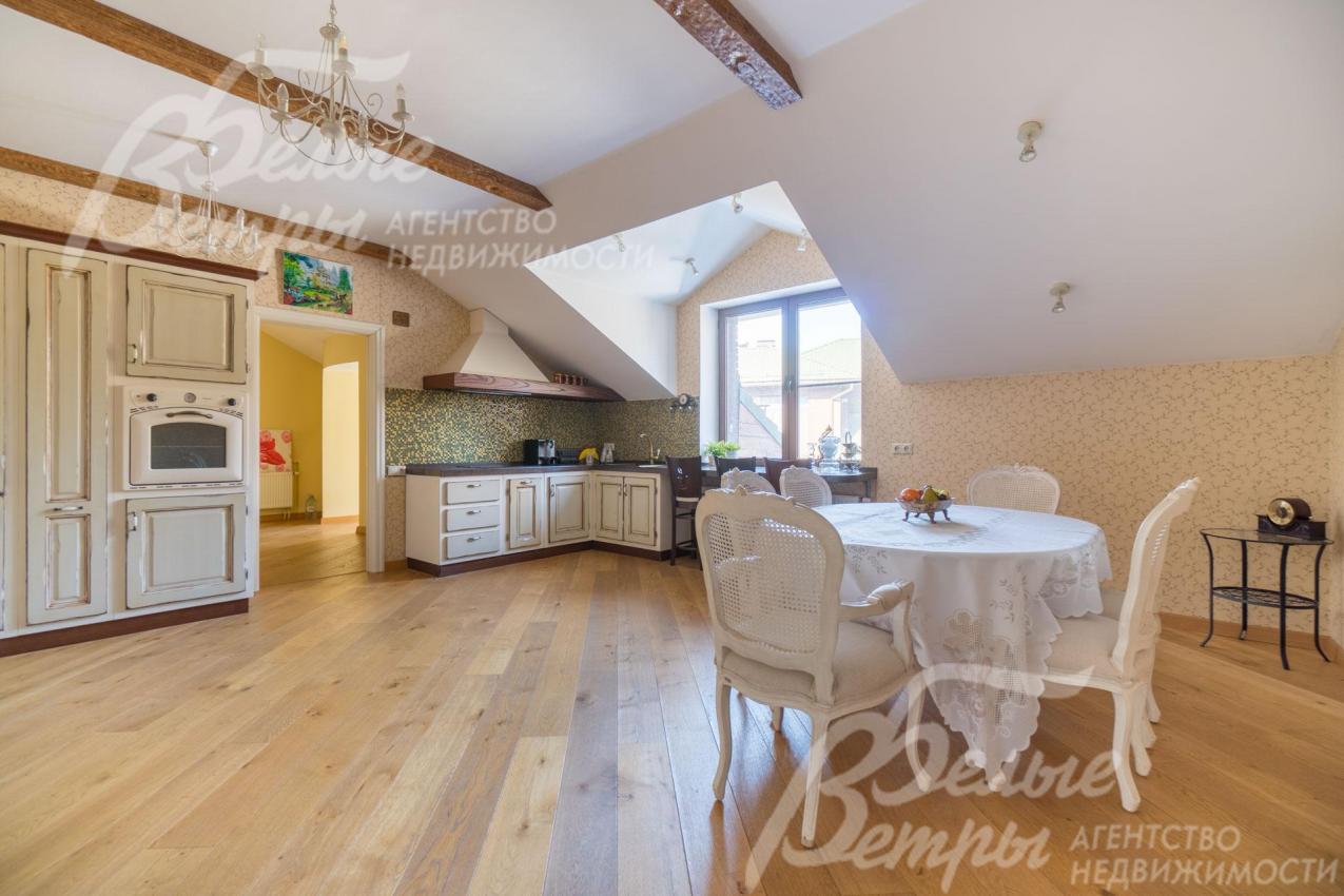 Светлая кухня-столовая в гостевой зоне с мебелью и техникой