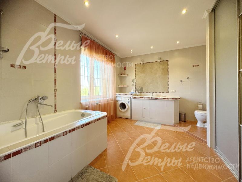 Просторный санузел с ванной и стиральной машиной на втором этаже
