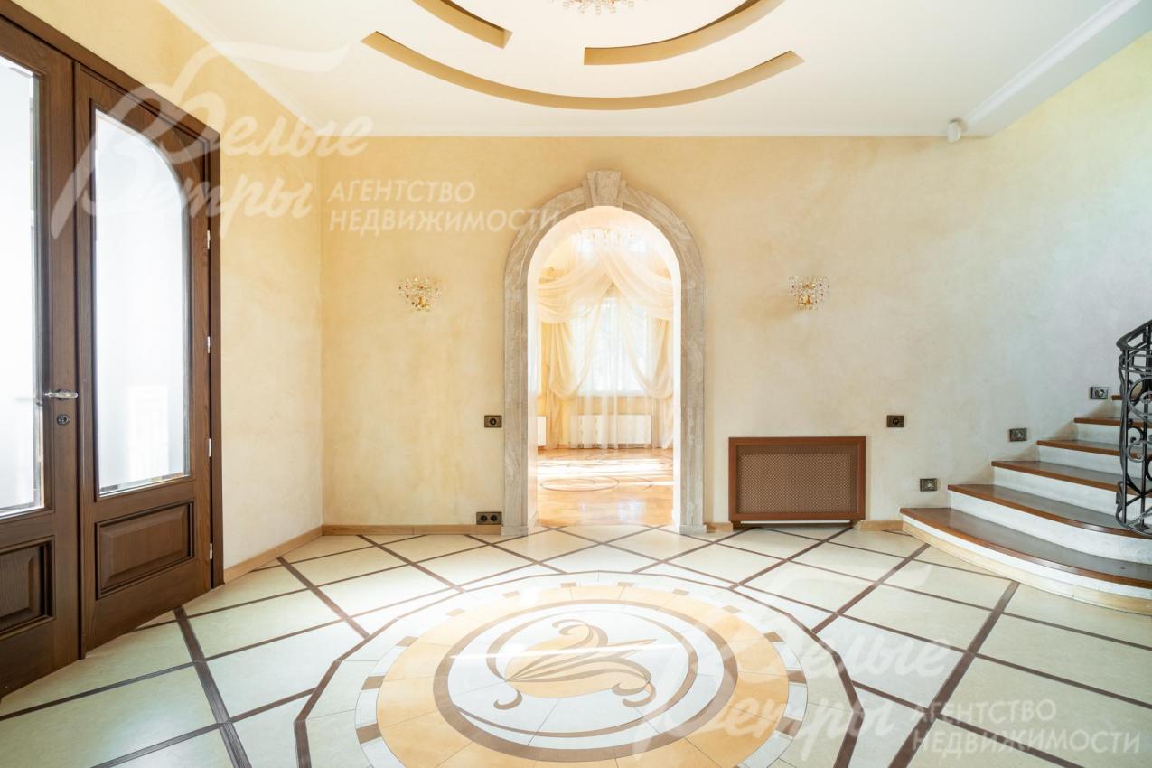 Светлая просторная прихожая с декоративной плиткой на полу