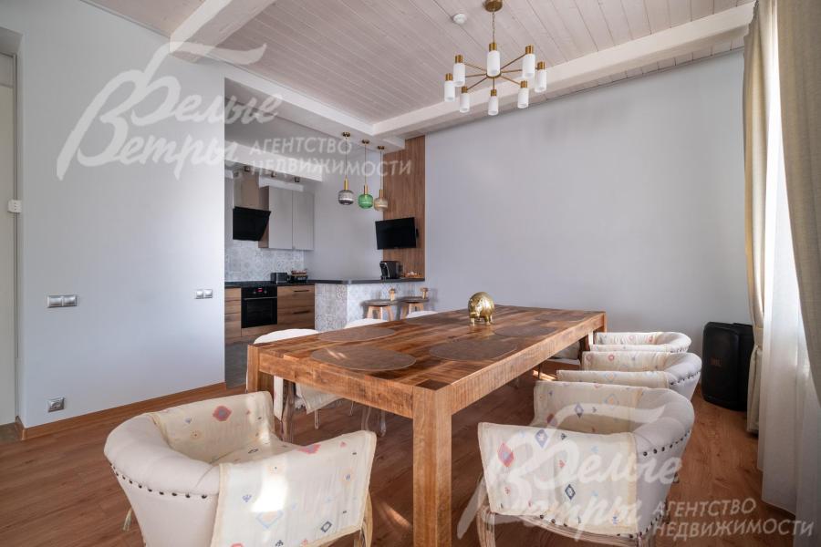 В столовой установлен большой эффектный обеденный стол на 10 персон из дерева манго