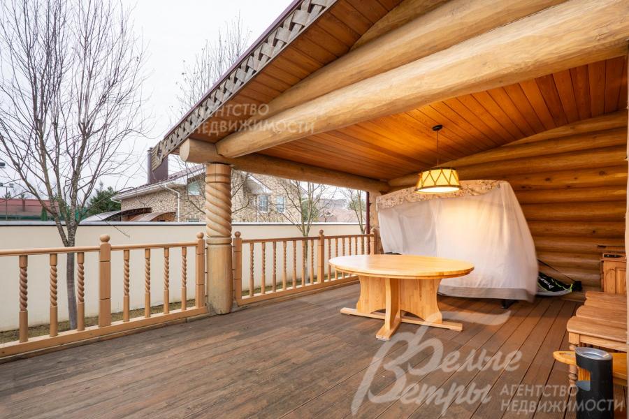 Крытая часть террасы с деревянной мебелью