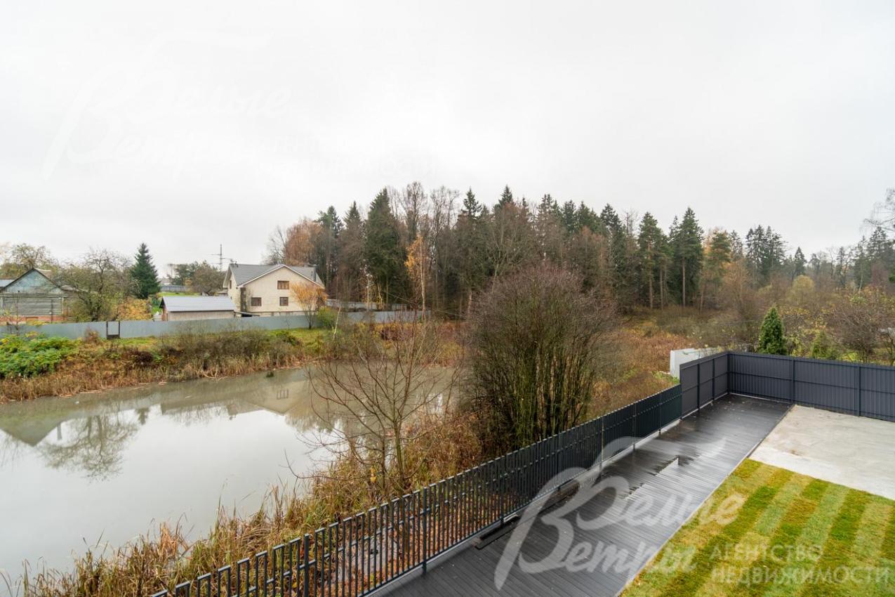 Вид с одного из балконов на втором этаже: панорама на пруд и прилесок